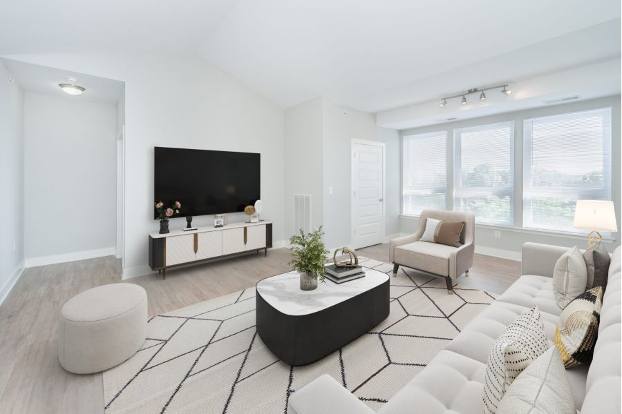 Infinity apartment homes with Modern living room with neutral décor, large windows, a TV, and comfortable seating around a coffee table.