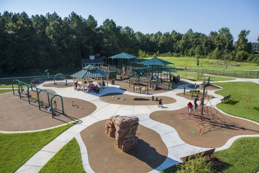 Infinity at Centerville Crossing A large playground with slides, swings, climbing structures, and kids playing on a sunny day.