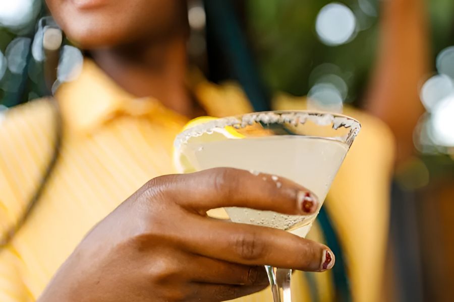 Infinity at Centerville Crossing Woman smiling and holding a margarita glass with a salted rim, wearing a yellow shirt.