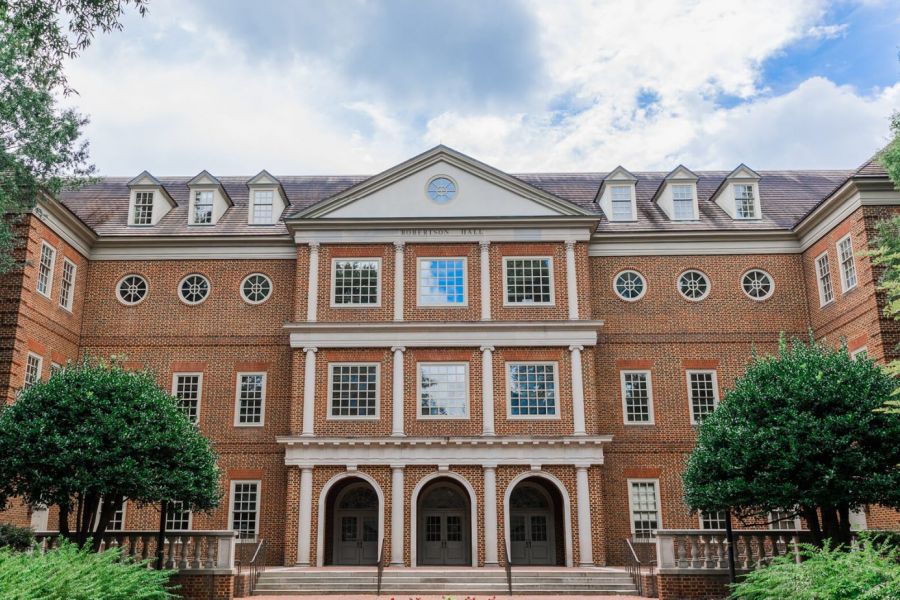 Infinity at Centerville Crossing Symmetrical brick university building with arched entrances, many windows, and trees on both sides.