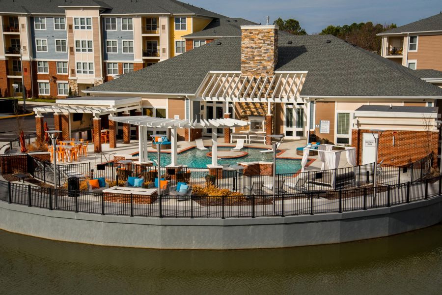 Infinity at Centerville Crossing Outdoor pool area at an apartment complex with lounge chairs, cabana, and modern seating by the water.