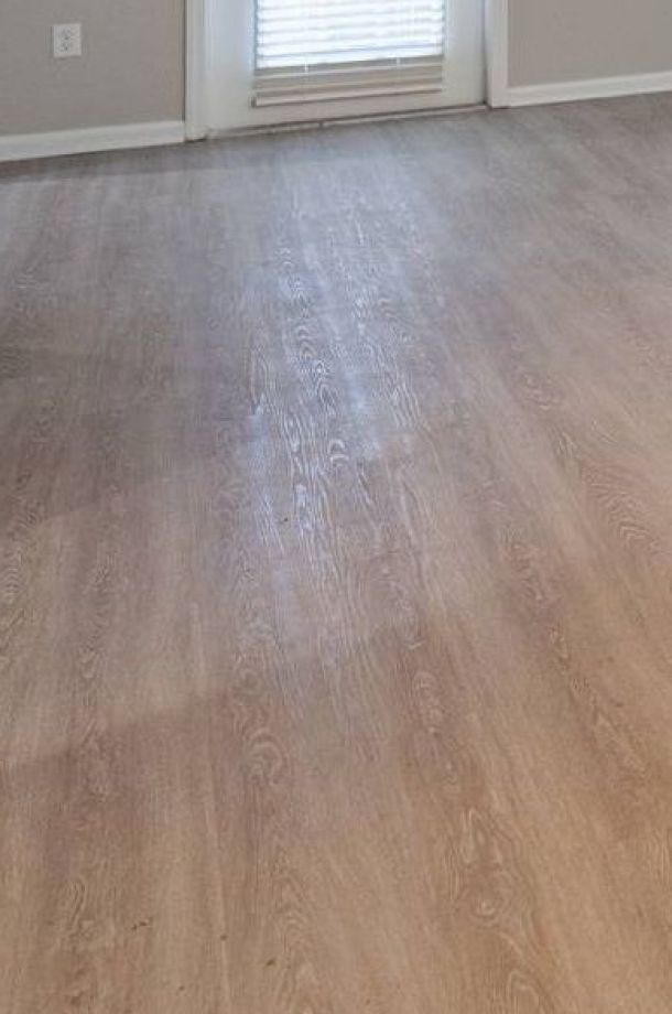 Infinity Crossings Apartments with Empty room with light wood flooring, beige walls, and a window with closed blinds letting in some light.